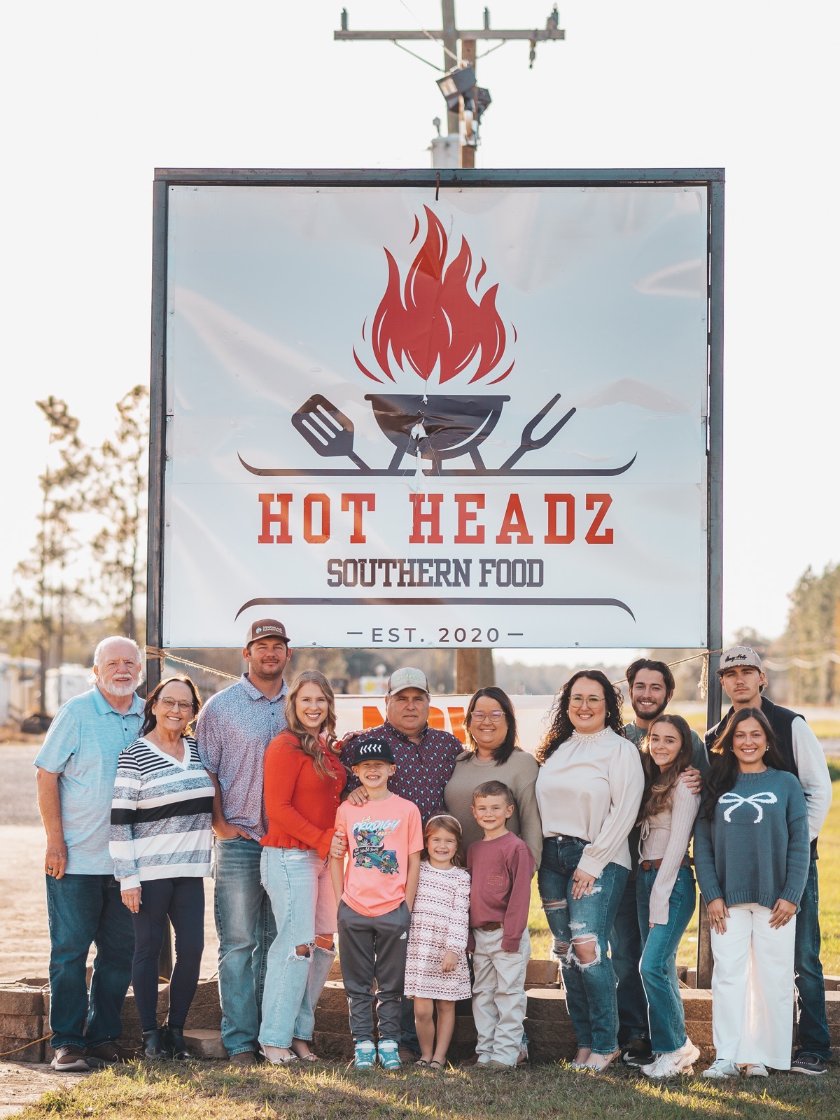 The Hot Headz family together in front of their Southern Food sign in DeRidder, Louisiana