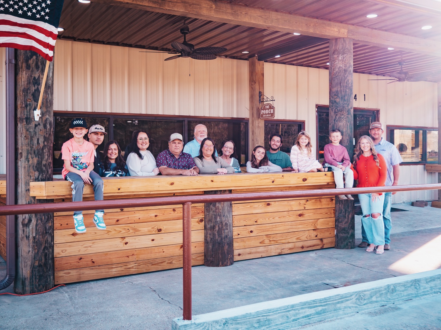 The Hot Headz family gathered on the porch with the American flag