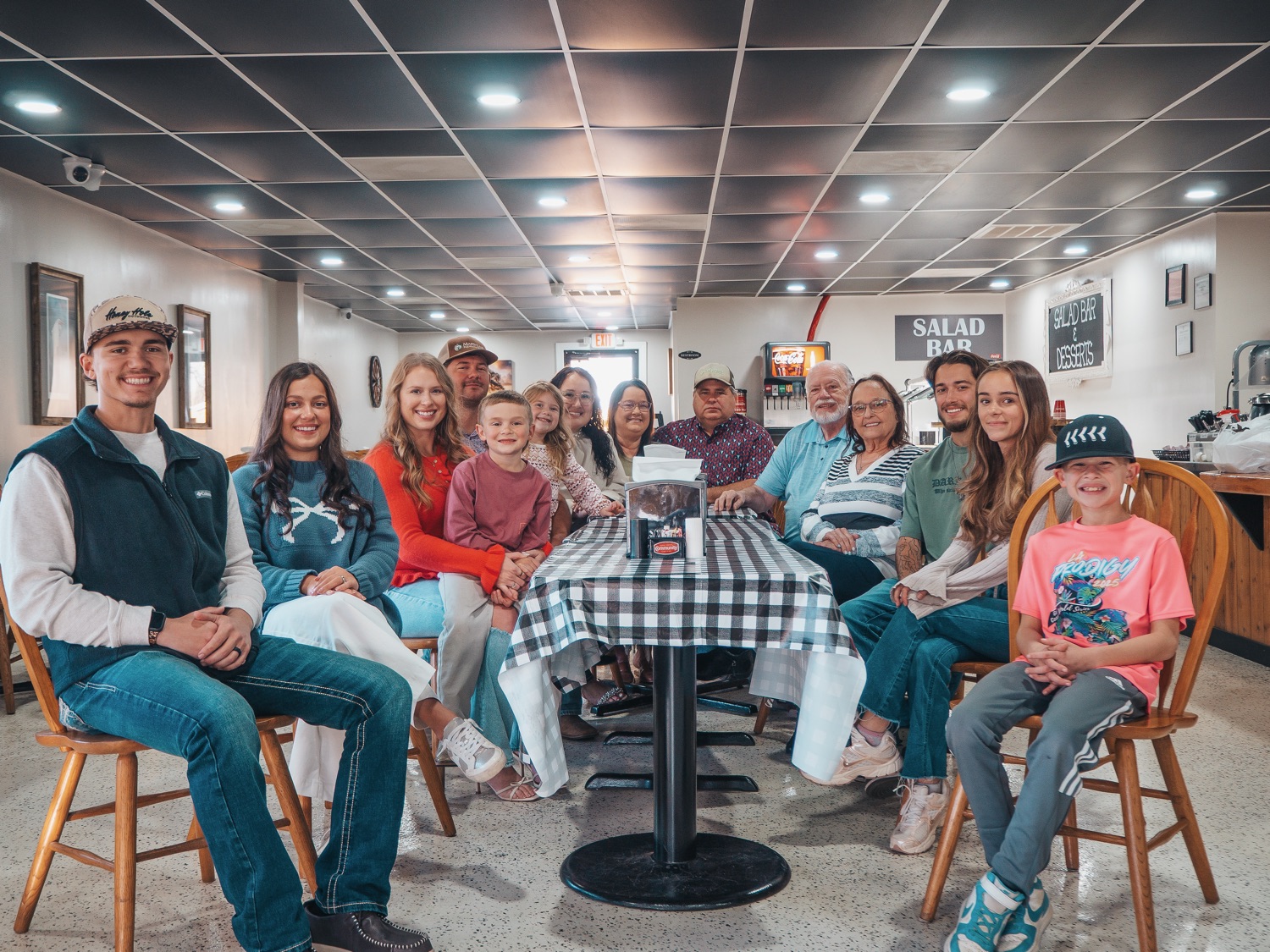 Family gathered at a table inside the Hot Headz dining room